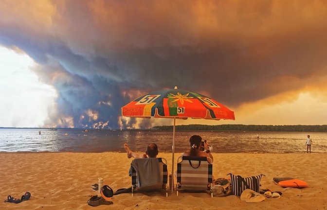 Ikonische Aufnahme in Südfrankreich: Während die Feuer toben, sitzen Touristen am Strand. Verdrändung ist in der Psychologie eine mächtige Kraft&nbsp;– und in der Politik.<span class='image-autor'>MAXIMILIEN LAMY/afp</span>