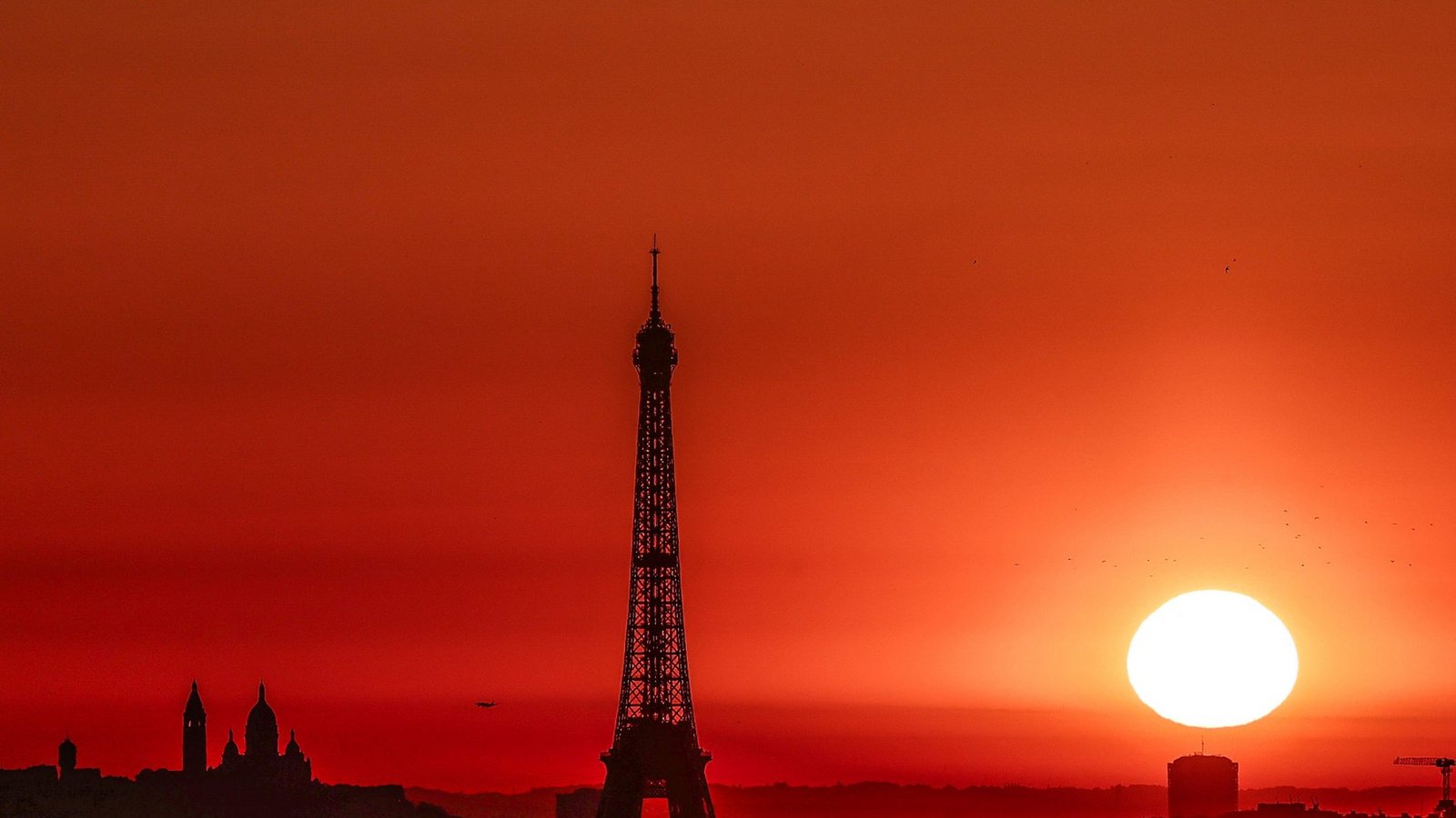 Die Sonne geht Anfang Juli 2025 über dem Eiffelturm und der Basilika Sacre Coeur auf dem Montmartre-Hügel auf, während in der Stadt wegen der hohen Temperaturen Alarmstufe Rot herrscht:Foto: Thibaud Moritz/AFP/dpa Die Sonne geht Anfang Juli 2025 über dem Eiffelturm und der Basilika Sacre Coeur auf dem Montmartre-Hügel auf, während in der Stadt wegen der hohen Temperaturen Alarmstufe Rot herrscht:Foto: Thibaud Moritz/AFP/dpa