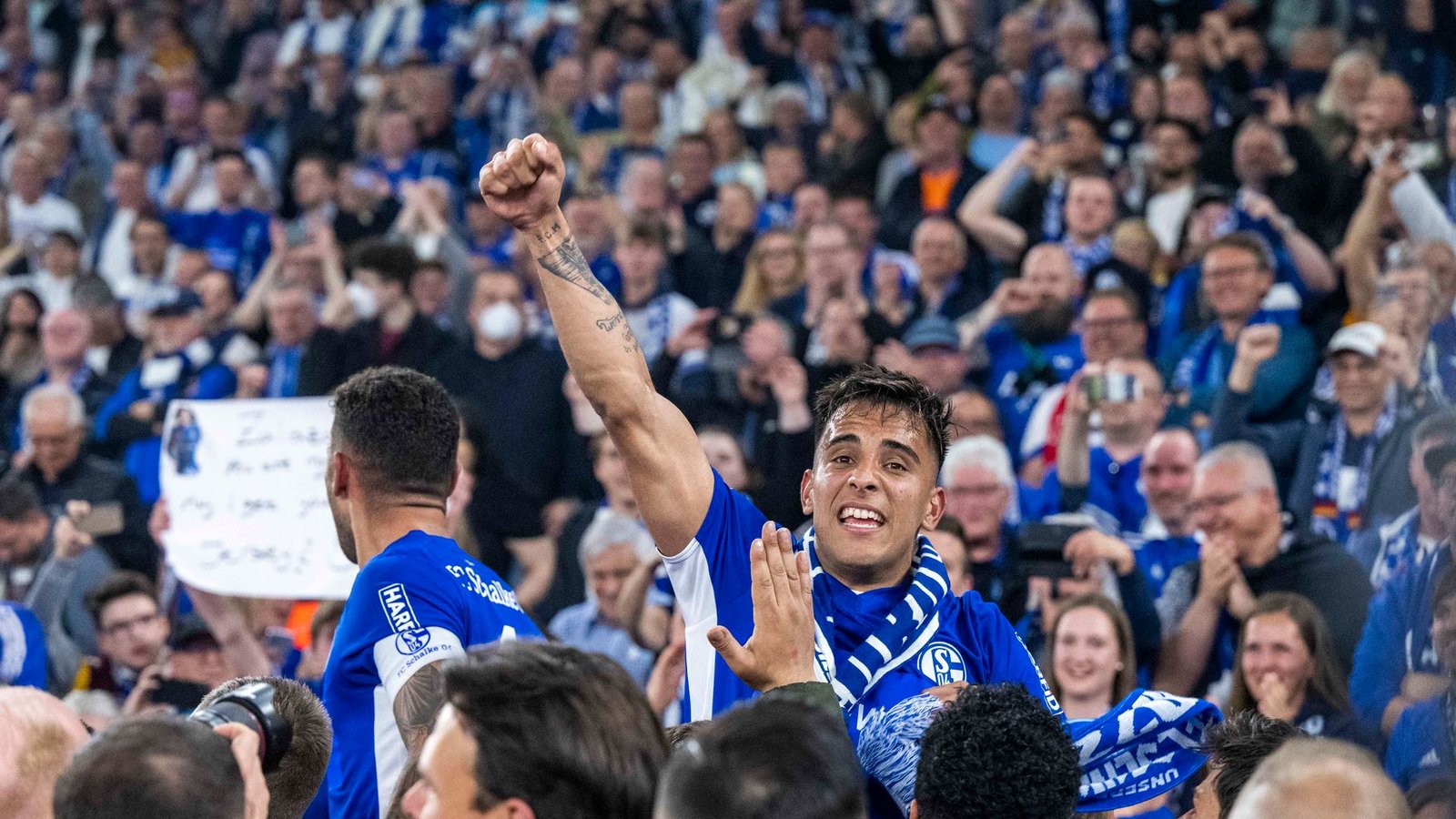 Schalkes Rodrigo Zalazar jubelt mit Fans über den Aufstieg.Foto: David Inderlied/dpa