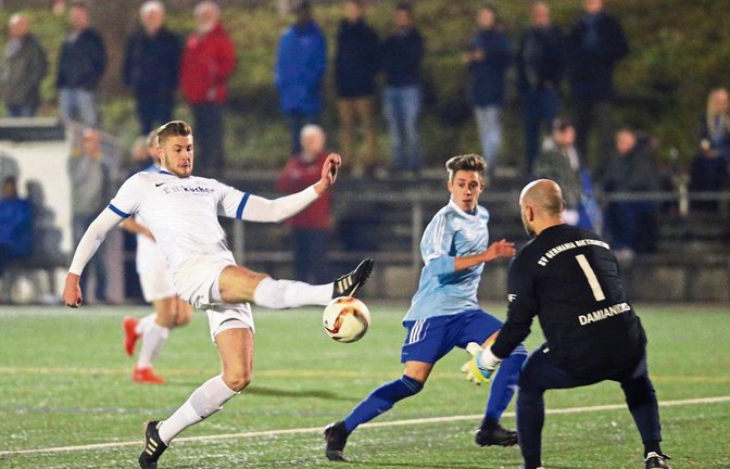 Auf dem Kunstrasen im Ellental schirmen Pascal Schöbinger (links) und Germania-Torwart Anastasios Damianidis den SGM-Angreifer Marc Tröger vom Ball ab. Das Nachholspiel der Bezirksliga endete gestern Abend 4:1 für die Gastgeber aus Bietigheim. Foto: Küppers