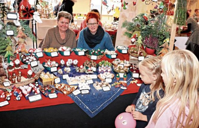 Beäugt von putzigen Engelchen stehen Vivienne und Lucy Eichler fasziniert vor den winzigen Hutzelzwergen, Buchenfeen, Eichelmännle und dem, singenden Wurzelsepp, die Sabine und Elisabeth Solfrank in Oberriexingen im Angebot hatten.  Fotos: Gergen