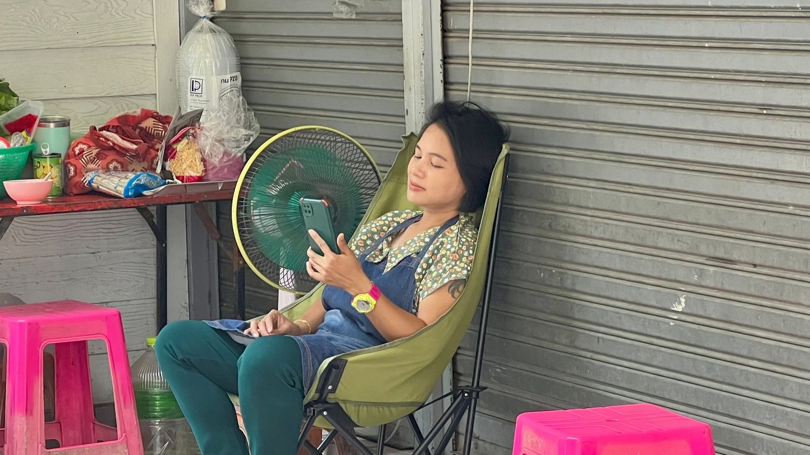 Im Schatten und mit Ventilator: Eine Frau in Bangkok versucht, sich sich abzukühlen.Foto: Carola Frentzen/dpa