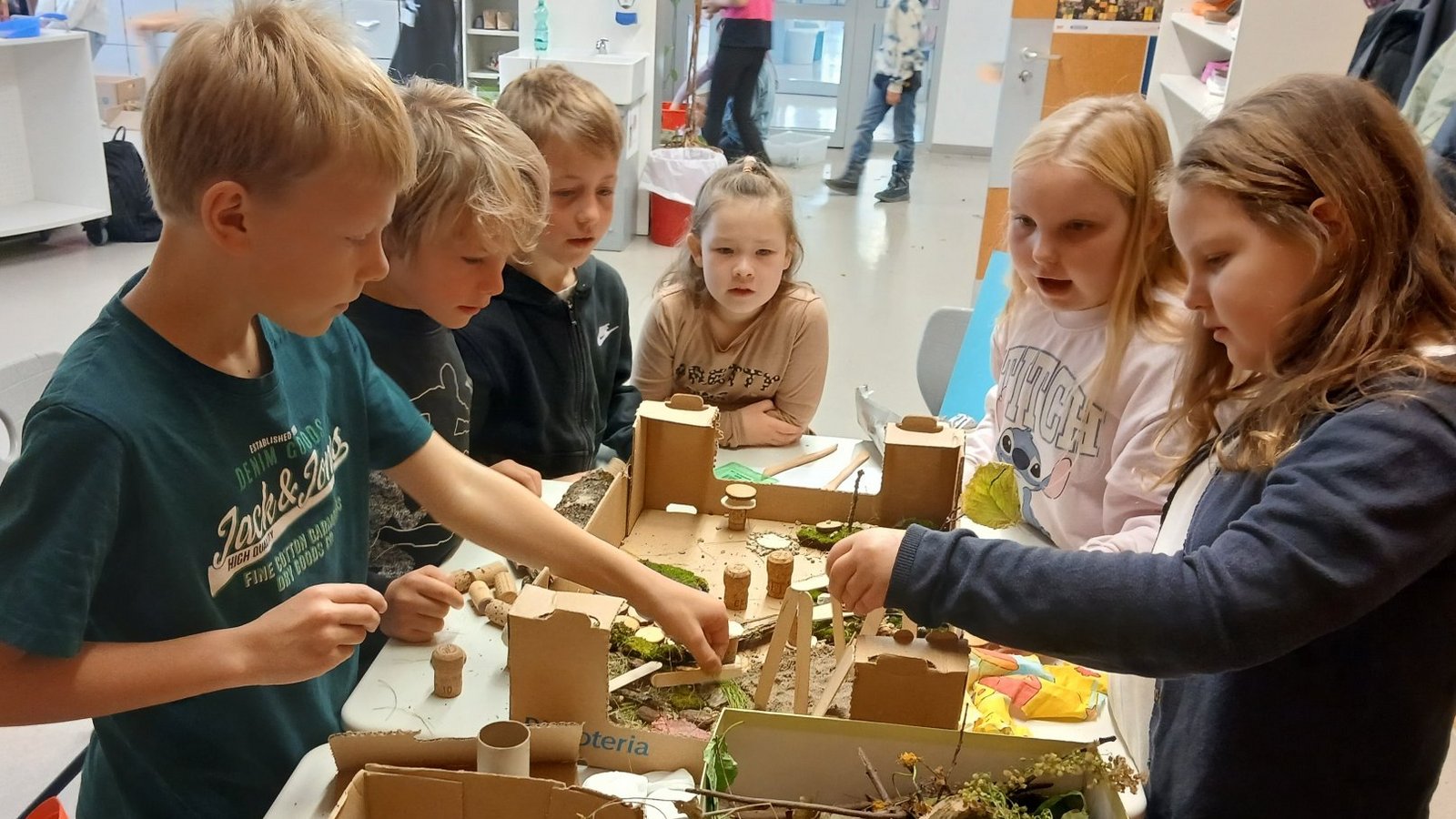 Die Viertklässler gestalten einen Schulhof mit unterschiedlichen Bereichen wie Wasser, Sand und Vogelnestschaukel.