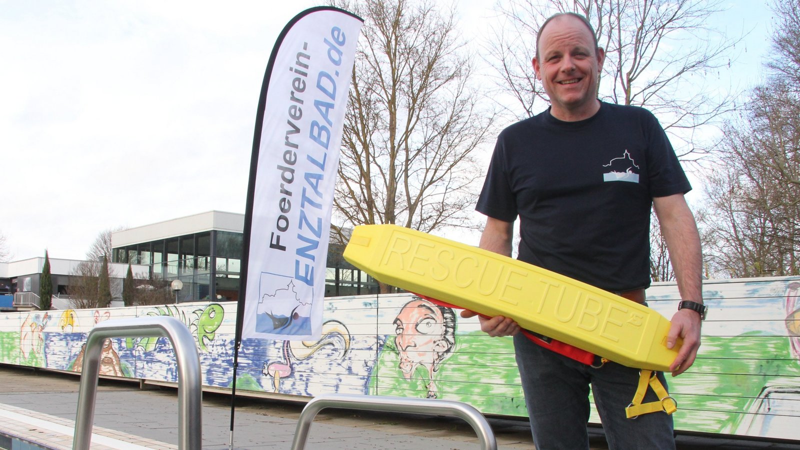 Damit das Rettungsschwimmer-Utensil, das Thomas Schmid in Händen hält, möglichst selten gebraucht wird, ist es wichtig, dass Kinder früh das Schwimmen erlernen. Dafür brauche es das Enztalband, betont der Vorsitzende des Fördervereins. Um der Stadt beim Sparen von Heizkosten zu helfen, möchte der Verein die Beckenabdeckung instandsetzen, die sich in dem Kasten im Hintergrund befindet. Foto: Banholzer Damit das Rettungsschwimmer-Utensil, das Thomas Schmid in Händen hält, möglichst selten gebraucht wird, ist es wichtig, dass Kinder früh das Schwimmen erlernen. Dafür brauche es das Enztalband, betont der Vorsitzende des Fördervereins. Um der Stadt beim Sparen von Heizkosten zu helfen, möchte der Verein die Beckenabdeckung instandsetzen, die sich in dem Kasten im Hintergrund befindet. Foto: Banholzer