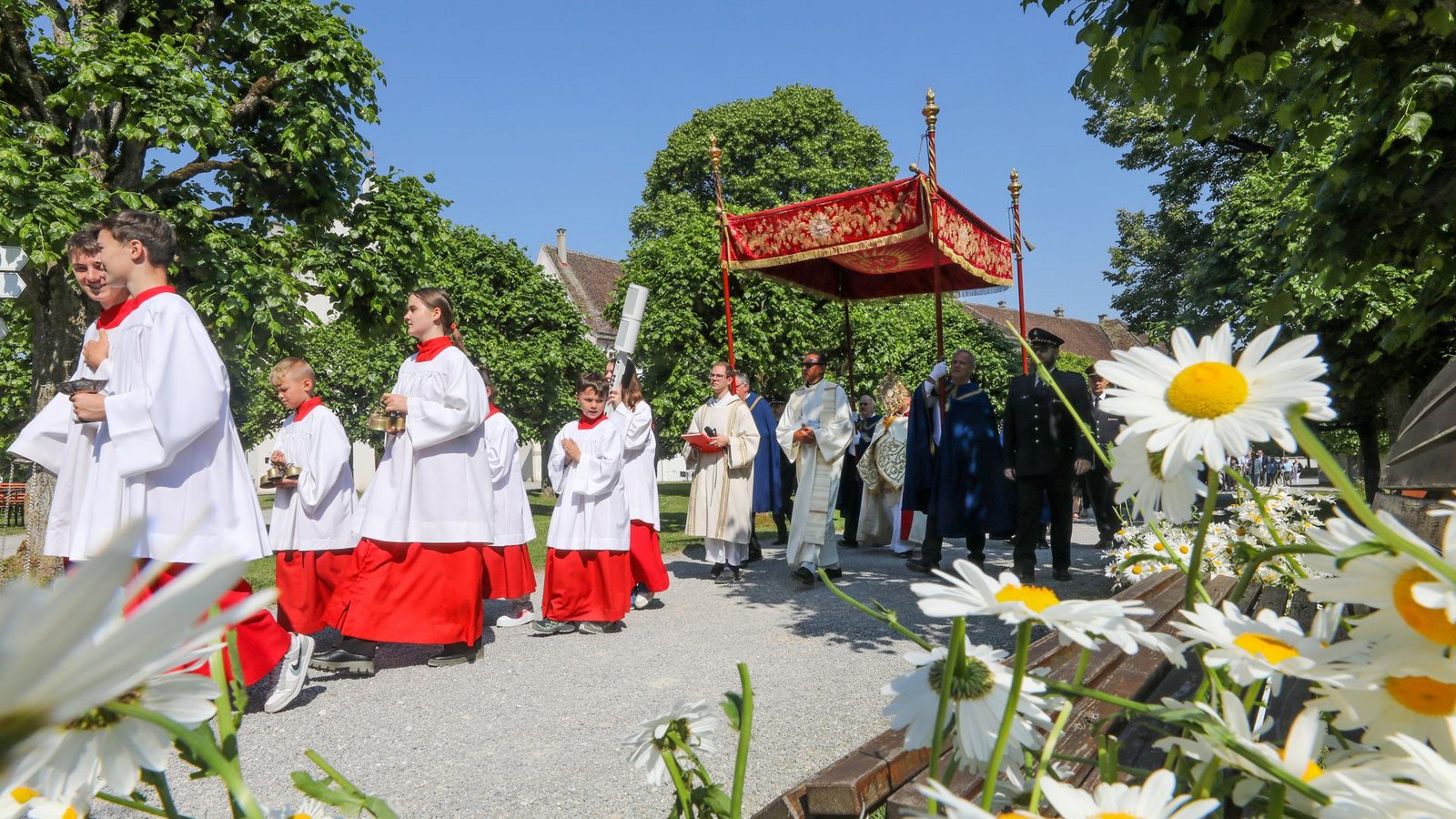 Unter einem Stoffbaldachin wird die Monstranz während der Fronleichnamsprozession am 8. Juni 2023 durch die Straßen des Dorfes Obermarchtal  getragen.Foto: dpa/Thomas Warnack