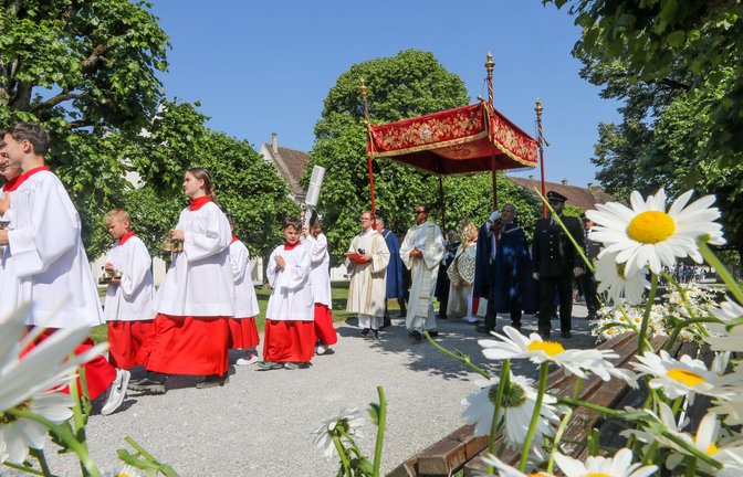 Unter einem Stoffbaldachin wird die Monstranz während der Fronleichnamsprozession am 8. Juni 2023 durch die Straßen des Dorfes Obermarchtal  getragen.<span class='image-autor'>Foto: dpa/Thomas Warnack</span>