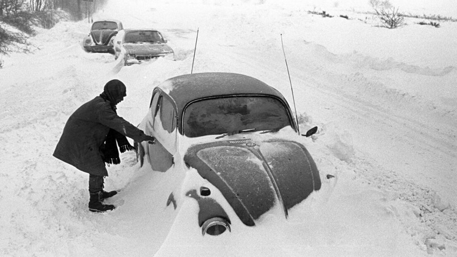 Ein Autofahrer steht in Cuxhaven neben seinem am Straßenrand im Schnee stecken gebliebenen VW-Käfer.Foto: dpa