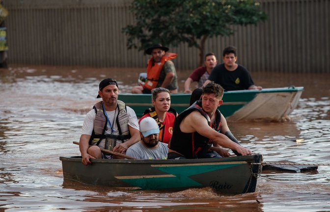 Mitglieder eines Rettungsteams bei der Evakuierung von Menschen, die von einer Überschwemmung betroffen sind.<span class='image-autor'>Foto: Claudia Martini/XinHua/dpa</span>