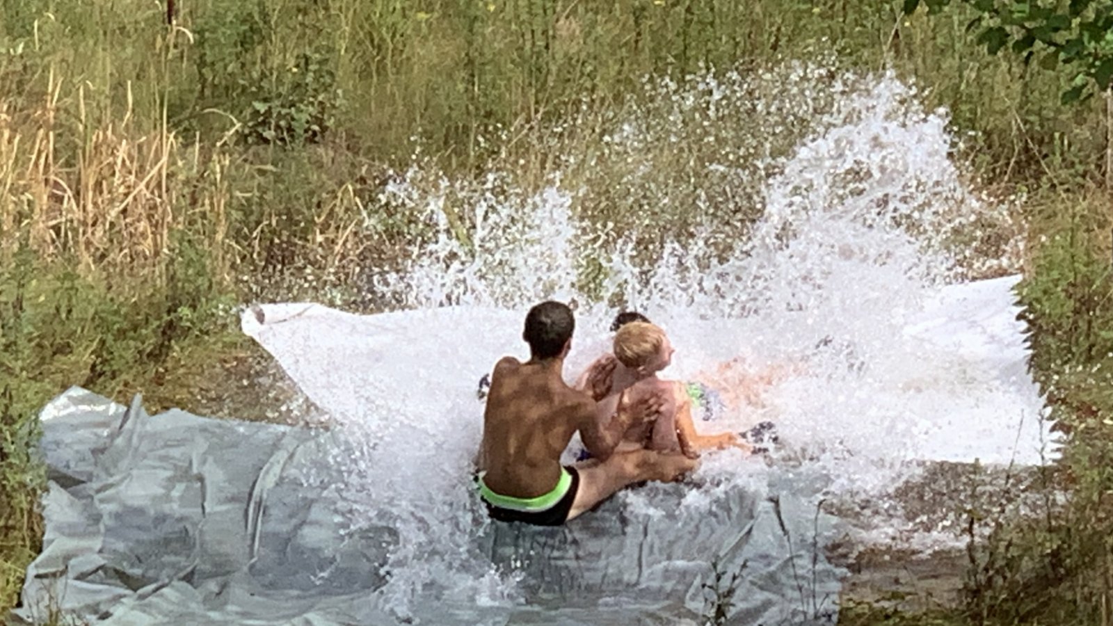 Bei durchwachsenem Wetter gab es wieder eine Wasserrutsche beim Ensinger Sommerferienprogramm. Die wenigen Kinder, die teilnahmen, hatten ihren Spaß, den auch ein kleiner Schauer nicht trüben konnte. Auf einer Folie, ausgelegt am Regenrückhaltebecken im Industriegebiet Ensingen Süd und mit einem Schwall Wasser, ging es abwärts.