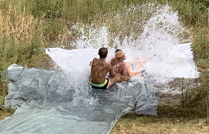 Bei durchwachsenem Wetter gab es wieder eine Wasserrutsche beim Ensinger Sommerferienprogramm. Die wenigen Kinder, die teilnahmen, hatten ihren Spaß, den auch ein kleiner Schauer nicht trüben konnte. Auf einer Folie, ausgelegt am Regenrückhaltebecken im Industriegebiet Ensingen Süd und mit einem Schwall Wasser, ging es abwärts.