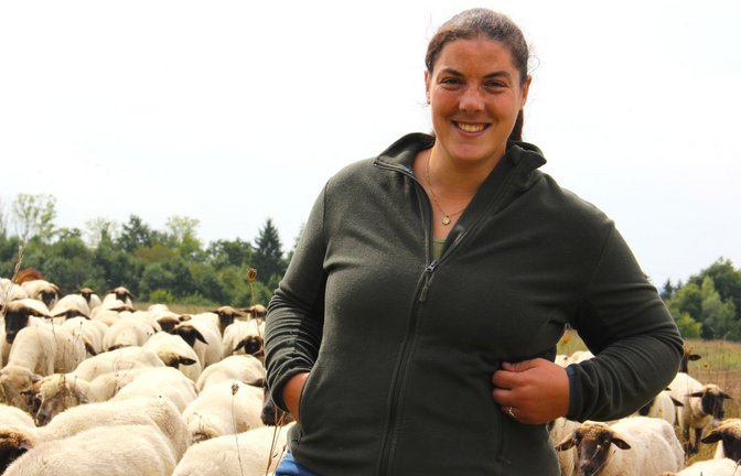 Elischa Serpi inmitten ihrer Herde. Das Schwarzköpfige Fleischschaf eigne sich besonders für die Weide, sagt die 30-Jährige.<span class='image-autor'>Foto: Uli Fricker</span>