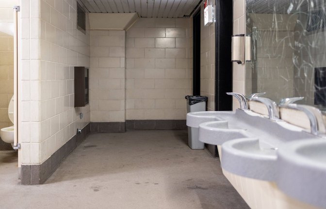 Innenansicht einer öffentlichen Toilettenanlage mit Waschbecken, Urinalen und einzelnen WC-Kabinen. Der Raum ist funktional gestaltet mit Fliesenwänden, Trennwänden und standardisierten Sanitäranlagen. Mulmig ist es einem trotzdem, wenn man an einem solchen Ort muss.<span class='image-autor'>Foto: IMAGO/Mario Aurich</span>