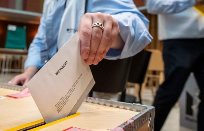 Eine Wählerin wirft in einem Wahllokal im Rathaus von Malmö ein Wahlumschlag in eine Wahlurne.<span class='image-autor'>Johan Nilsson/TT News Agency via AP/dpa</span>
