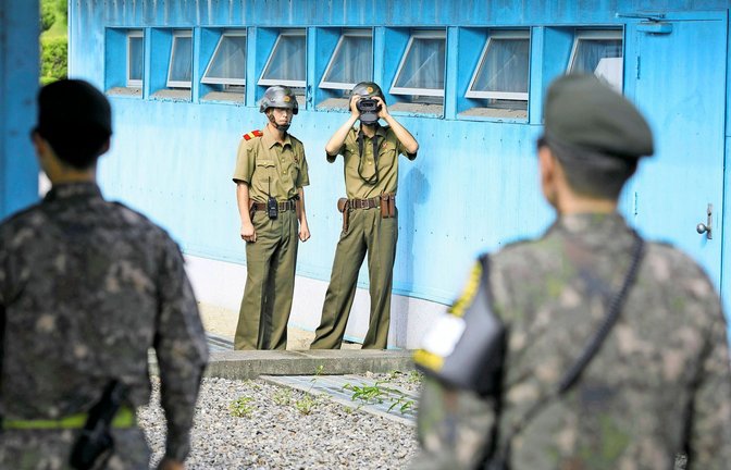 Nordkoreanische Soldaten beobachten südkoreanische Soldaten an den Blauen Baracken der demilitarisierten Zone in Panmunjeom/Korea.<span class='image-autor'>Foto: imago//Thomas Imo</span>