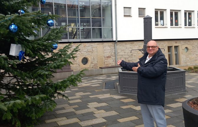 Bürgermeister Jürgen Scholz steht voller Stolz am Weihnachtsbaum vor dem neu gestalteten Platz am Schlösslesbrunnen in der Ortsmitte der Gemeinde Sersheim.  <span class='image-autor'>Fotos: Glemser (2)/Archiv</span>