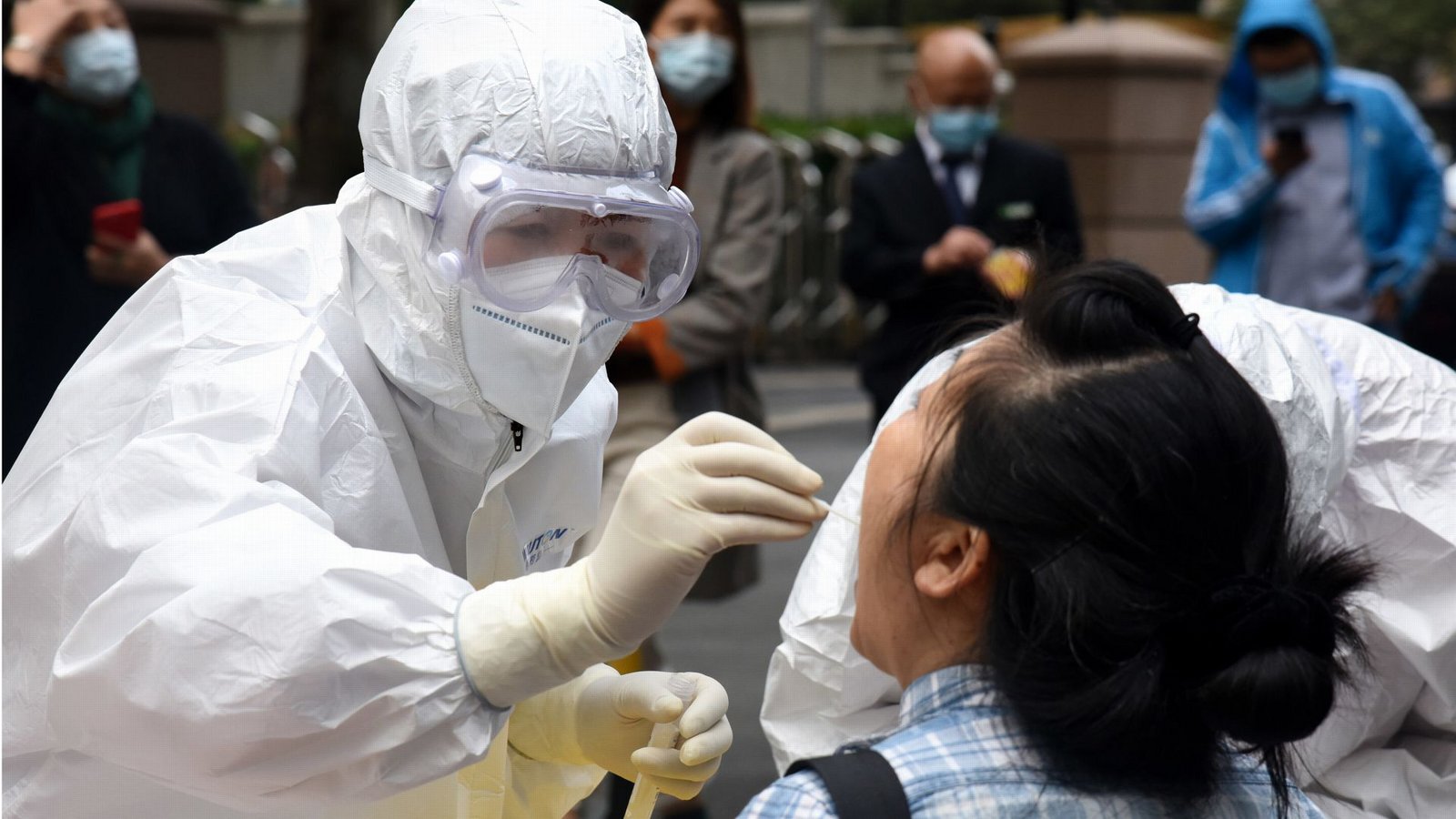 Archivbild aus dem Jahr 2020: Ein Mitarbeiter des Gesundheitswesens im Schutzanzug entnimmt einer Frau in Qingdao eine Abstrichprobe für den COVID-19-Test.Foto: dpa/Li Ziheng Archivbild aus dem Jahr 2020: Ein Mitarbeiter des Gesundheitswesens im Schutzanzug entnimmt einer Frau in Qingdao eine Abstrichprobe für den COVID-19-Test.Foto: dpa/Li Ziheng