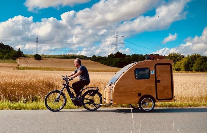 Erich Zeller aus Neckargemünd präsentiert auf der CMT seinen Fahrrad-Wohnwagen – nicht viel größer als das Rad selbst.<span class='image-autor'>Foto: I:Woody</span>