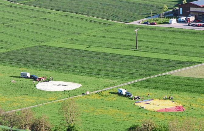 Die runden Strukturen, die ein bisschen wie mysteriöse Kornkreise wirken, sind bei genauerem Hinsehen zwei Heißluftballons, die kurz vor dem Start am Freitagabend in Roßwag darauf warten, mit Luft gefüllt zu werden.  Foto: Banholzer