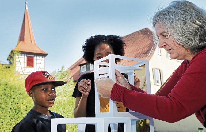 Im Garten von Kirche und Gemeindehaus unterstützt die Schützinger Pfarrerin Sigrid Telian ihre jungen Gäste beim Bau von Murmelbahnen aus Pappe. Fotos: Küppers