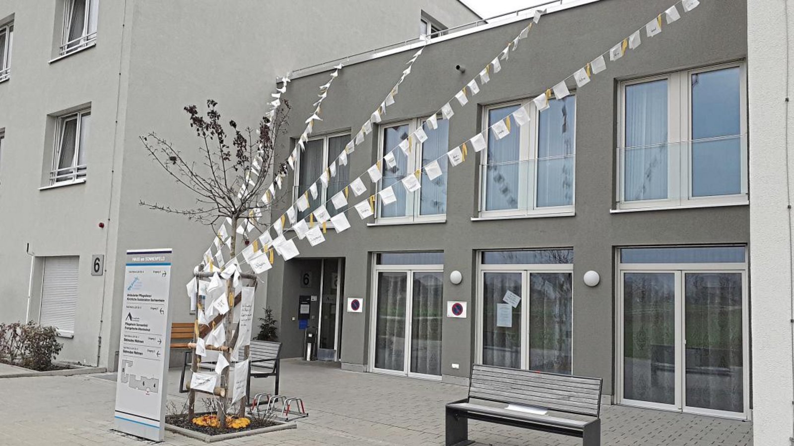 Die weißen Wünschefahnen flattern vor dem Eingang des Pflegeheims „Sonnenfeld“ in Großsachsenheim schon im Wind. Die anderen Teile einer Freiluftausstellung werden noch bis Sonntag aufgebaut. Foto: Glemser