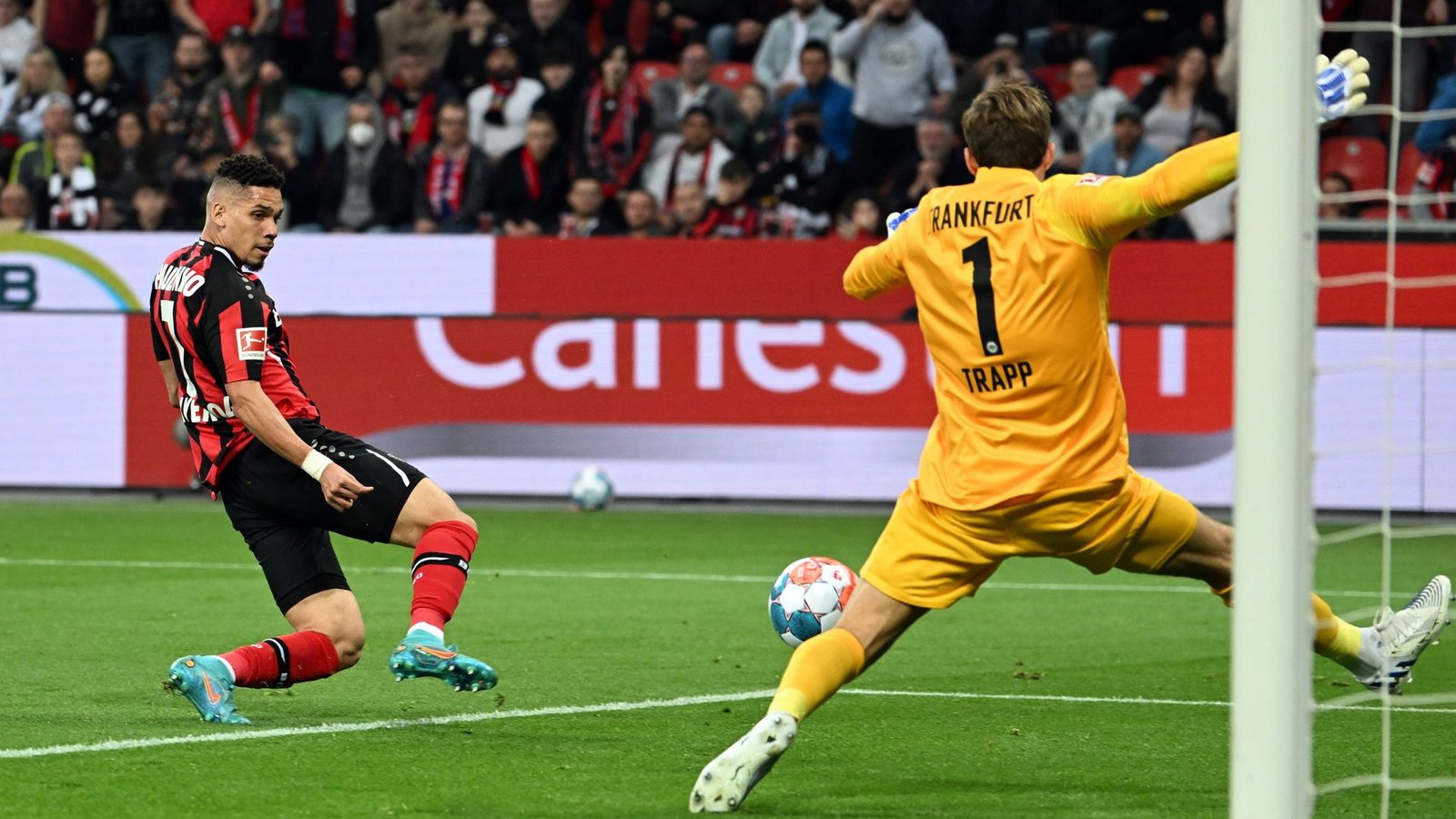 Leverkusens Paulinho (l) erzielt das 1:0 gegen Frankfurts Torhüter Kevin Trapp .Foto: Federico Gambarini/dpa