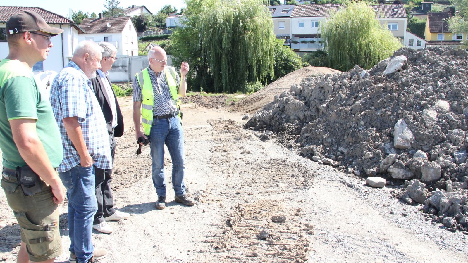 Vorarbeiter Elmar Ziegler, Bauunternehmer Ernst Sievers, Bürgermeister Armin Pioch und Bauleiter Jochen Müller (von links) begutachten den angefallenen Bauschutt aus dem alten Bachbett.