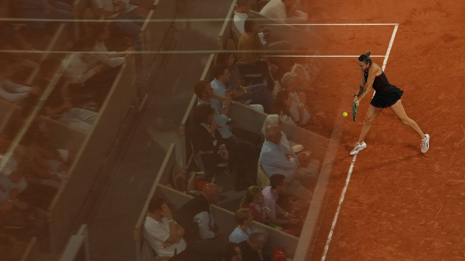 Die Fans spiegeln sich in einer Glaswand bei den French Open, während Aryna Sabalenka eine Rückhand gegen Naomi Osaka spielt.Foto: Aurelien Morissard/AP/dpa