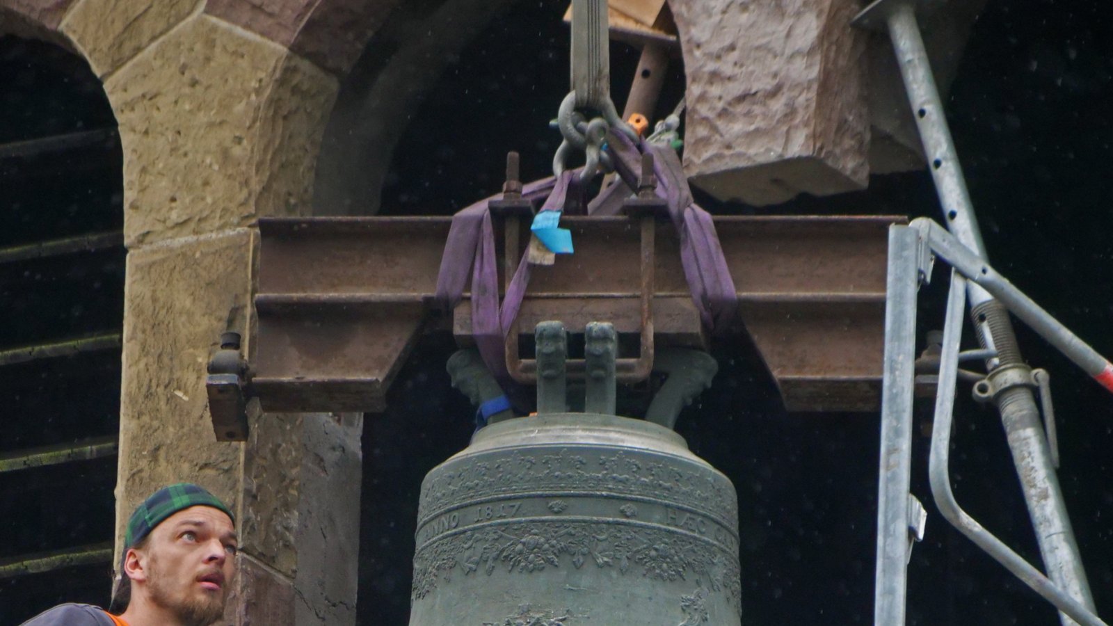 Es ist eine Millimeter-Arbeit: Experten des Glockengießers achten darauf, dass die polnische Glocke unbeschadet aus dem Kirchenturm gelangt, bei dem man für diesen Transport einen Teil des Mauerwerks vorübergehend entfernt hat. Foto: Friedrich