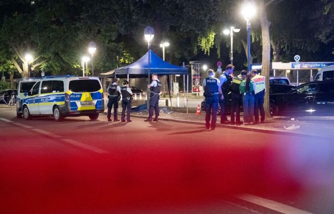 Polizisten arbeiten an einem Tatort auf dem Parkplatz vor dem Bahnhof Zoologischer Garten.<span class='image-autor'>Christophe Gateau/dpa</span>