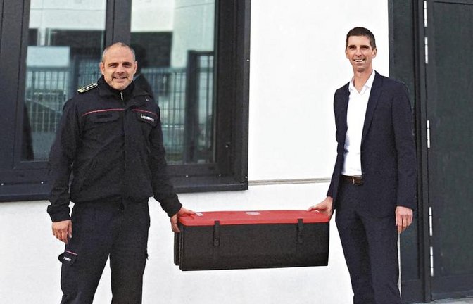 Der Leiter des Dräxlmaier-Standortes in Sachsenheim, Gunther Wössner (rechts), überreichte die großformatige Löschdecke Feuerwehr-Kommandanten Philipp Rousta.  Foto: p