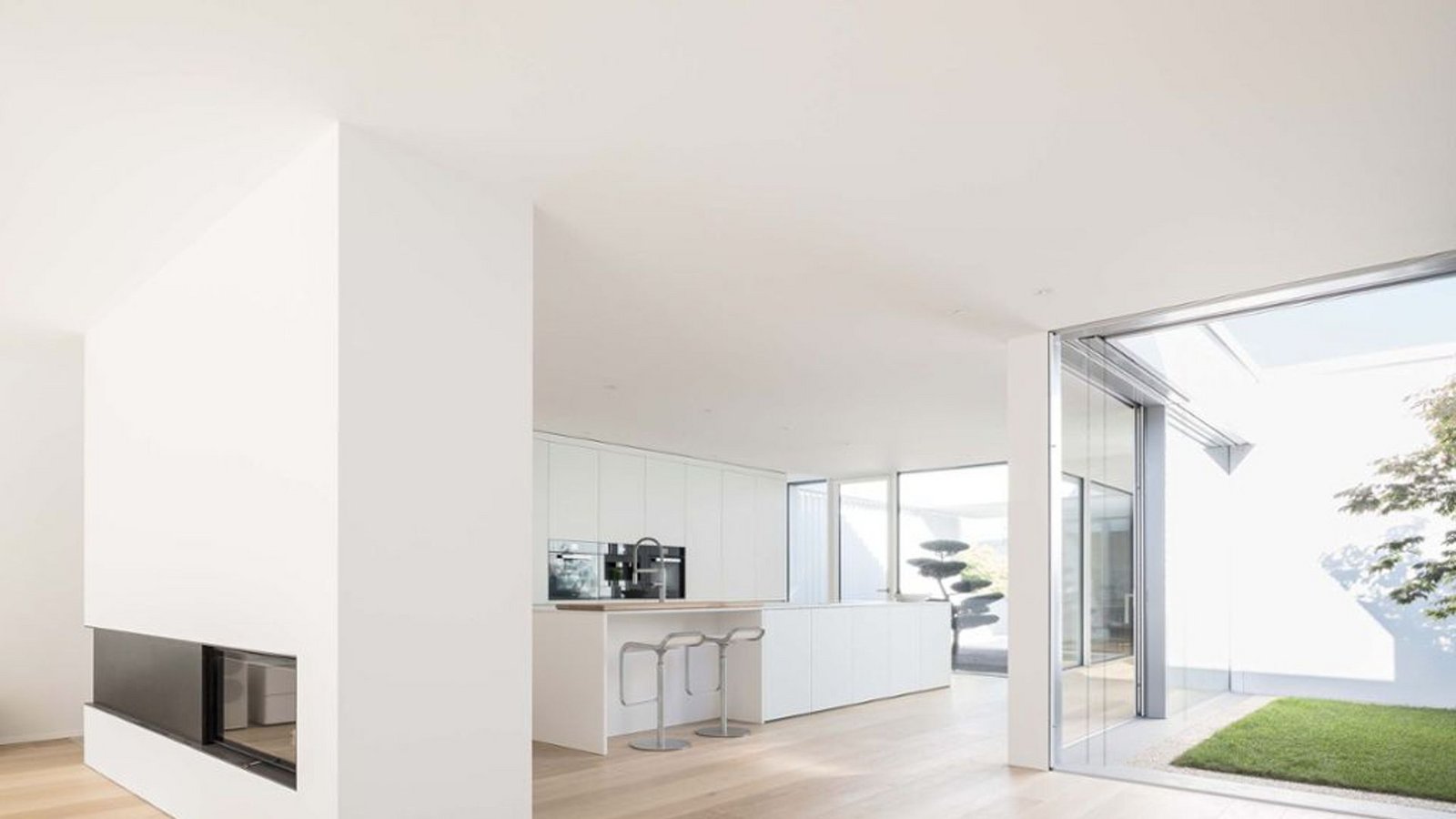 Blick  in die Küche und auf den Kamin, der als Raumteiler zwischen Wohnzimmer und Essküche fungiert, entworfen wurde der Bungalow von dem Architekten Bernd Liebel.Foto: Brigida González