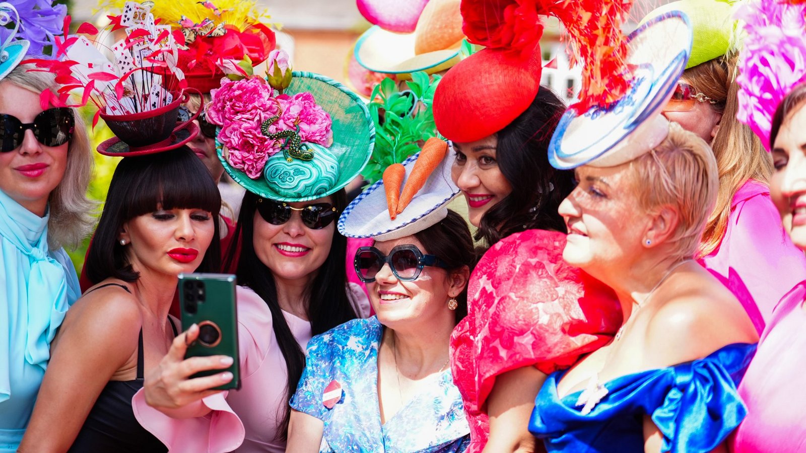 Bei Royal Ascot wird Kopfschmuck zur Hauptattraktion: Die Besucherinnen tragen Hüte und Fascinators in kräftigen Farben, mit Spielkarten, Federn, Blüten, Schleiern und skulpturalen Formen. Dazu dominieren farbintensive Kleider in Pink, Rot, Blau und Pastelltönen.Foto: picture alliance/dpa/PA Wire | Mike Egerton