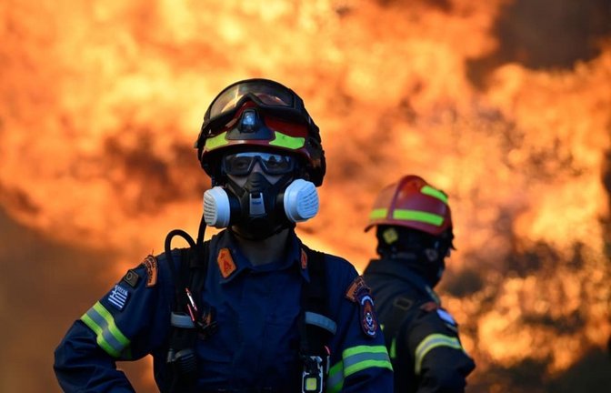 Ein Feuerwehrmann steht vor den lodernden Flammen eines Waldbrands in der Nähe von Porto Germeno, nordwestlich von Athen.<span class='image-autor'>Michael Varaklas/AP/dpa</span>