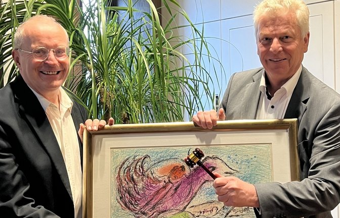 Der Auktionator Oberbürgermeister Jürgen Kessing (rechts) und der Vorstand der Stiftung für die Diakoniestation, Thomas Reusch-Frey, mit „La Baie“ („Die Bucht“) von Marc Chagall, einem der 83 Kunstwerke, die heute versteigert werden. <span class='image-autor'>Foto: p</span>