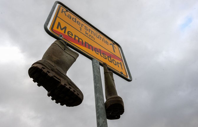 An einem Ortsschild im unterfränkischen Memmelsdorf (Landkreis Haßberge) hängen am Neujahrstag Gummistiefel.<span class='image-autor'>Foto: dpa/Pia Bayer</span>