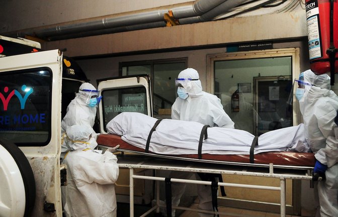 Sanitäter und Ärzte bringen einen der am Nipah-Virus Verstorbenen im indischen  Bundesstaat Kerala unter strengsten Sicherheitsvorkehrungen zur Untersuchung.<span class='image-autor'>Foto: AFP</span>