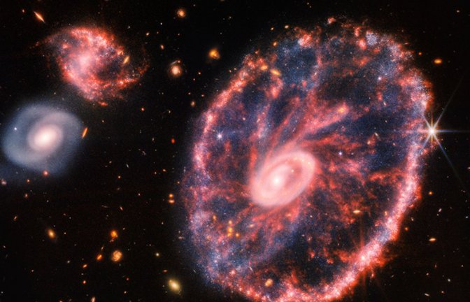 Dieses von der NASA zur Verfügung gestellte Handout-Foto zeigt eine große, rosa-blau gesprenkelte Galaxie, die einem Rad mit einem kleinen, inneren Oval ähnelt.<span class='image-autor'>Foto: Uncredited/NASA/AP/dpa</span>