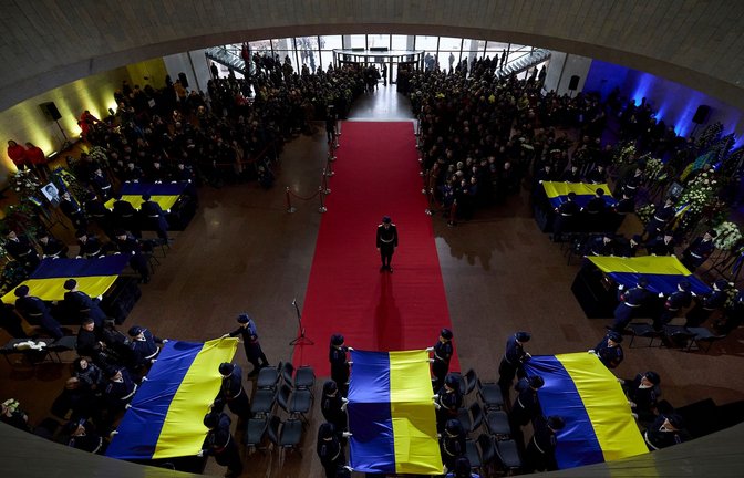 Ukrainische Ehrenwachen drapieren Flaggen auf den Särgen von Beamten des Innenministeriums, die bei einem Hubschrauberabsturz ums Leben gekommen sind. Unter ihnen war auch Innenminister Monastyrskyj.<span class='image-autor'>Foto: Ukraine Presidency/Planet Pix/Zuma Press/dpa</span>