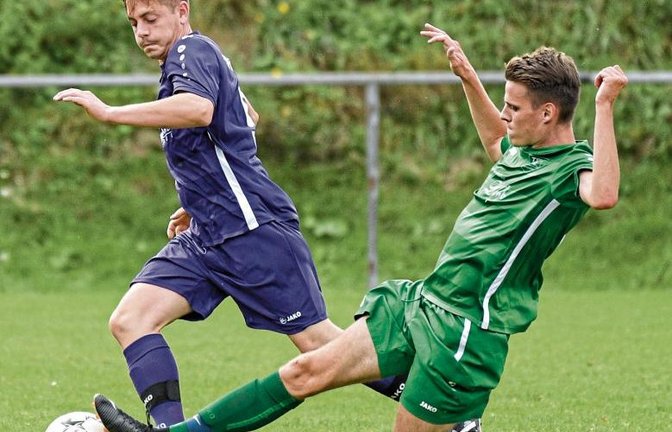 Kleinglattbachs Thomas Haupt (rechts) braucht ein ganz langes Bein, um den Ball Benjamin Schwab von der SGM Roßwag/Mühlhausen vom Fuß zu spitzeln. Foto: Leitner