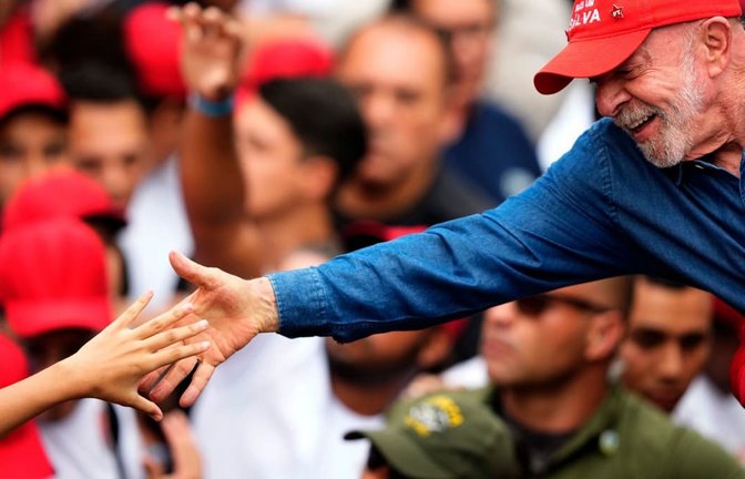 Der brasilianische Präsident Luiz Inácio Lula da Silva, der sich um eine Wiederwahl bewirbt, begrüßt einen Anhänger einen Tag vor der Stichwahl um das Präsidentenamt.<span class='image-autor'>Natacha Pisarenko/dpa</span>