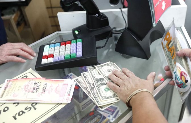 Symbolbild: Ein Kunde kauft "Mega Millions"-Lotterielose.<span class='image-autor'>picture alliance/ Wilfredo Lee/AP/dpa</span>
