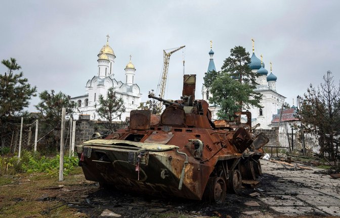 Ein zerstörter russischer Schützenpanzer steht vor einer Kirche in Isjum.<span class='image-autor'>Foto: Evgeniy Maloletka/AP/dpa</span>