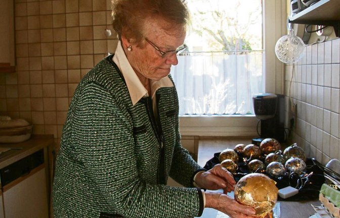 Hanna Monte überzieht die Glaskugel mit einer goldfarbenen Metallfolie. Gold ist besonders zur Weihnachtszeit beliebt. Fotos: Thomaser