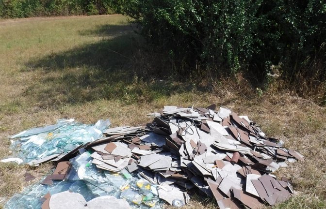 Illegale Müllablagerung auf der Wiese.  p