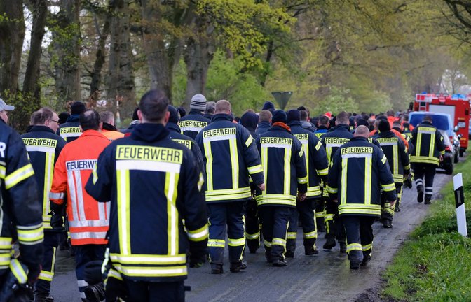 Feuerwehrleute laufen auf einer Straße bei Bremervörde. Von einem vermissten sechs Jahre alten Jungen aus dem niedersächsischen Bremervörde fehlt noch immer jede Spur.<span class='image-autor'>Foto: dpa/Markus Hibbeler</span>