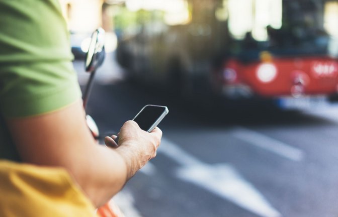 Der typische Griff an der Haltestelle geht zum Handy.<span class='image-autor'>Foto: stock.adobe.com/
Maria_Savenko</span>