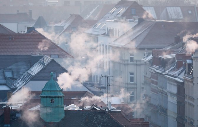 Rauch strömt aus Kaminen auf Dächern von Mehrfamilienhäuser.<span class='image-autor'>Foto: Jan Woitas/dpa</span>
