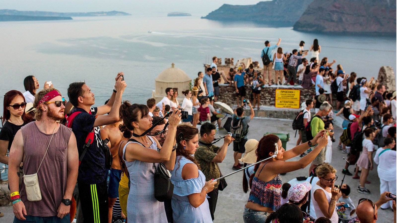 Touristen fotografieren den Sonnenuntergang nahe Oia auf Santorin: Übertourismus – ein bekanntes Bild.Foto: dpa/Angelos Tzortzinis Touristen fotografieren den Sonnenuntergang nahe Oia auf Santorin: Übertourismus – ein bekanntes Bild.Foto: dpa/Angelos Tzortzinis