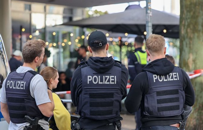 Polizisten stehen vor einem Absperrband. Zwei Unbekannte haben mitten in Essen zwei Justizbeamte angegriffen und einen 34 Jahre alten Häftling befreit. Die beiden Justizbediensteten, die den Gefangenen in eine Arztpraxis bringen sollten, wurden nach Informationen der Deutschen Presse-Agentur überwältigt und gefesselt.<span class='image-autor'>Matthias Rosenkranz/dpa</span>