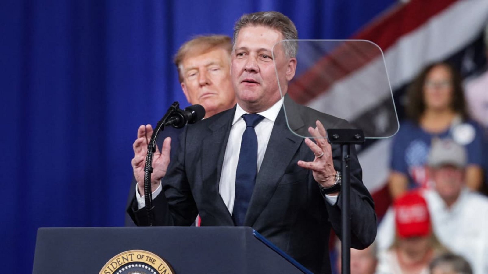 Audi-CEO Gernot Döllner trat ans Mikrofon, während US-Präsident Donald Trump hinter im zuhörte.Alex Wong/afp Audi-CEO Gernot Döllner trat ans Mikrofon, während US-Präsident Donald Trump hinter im zuhörte.Alex Wong/afp